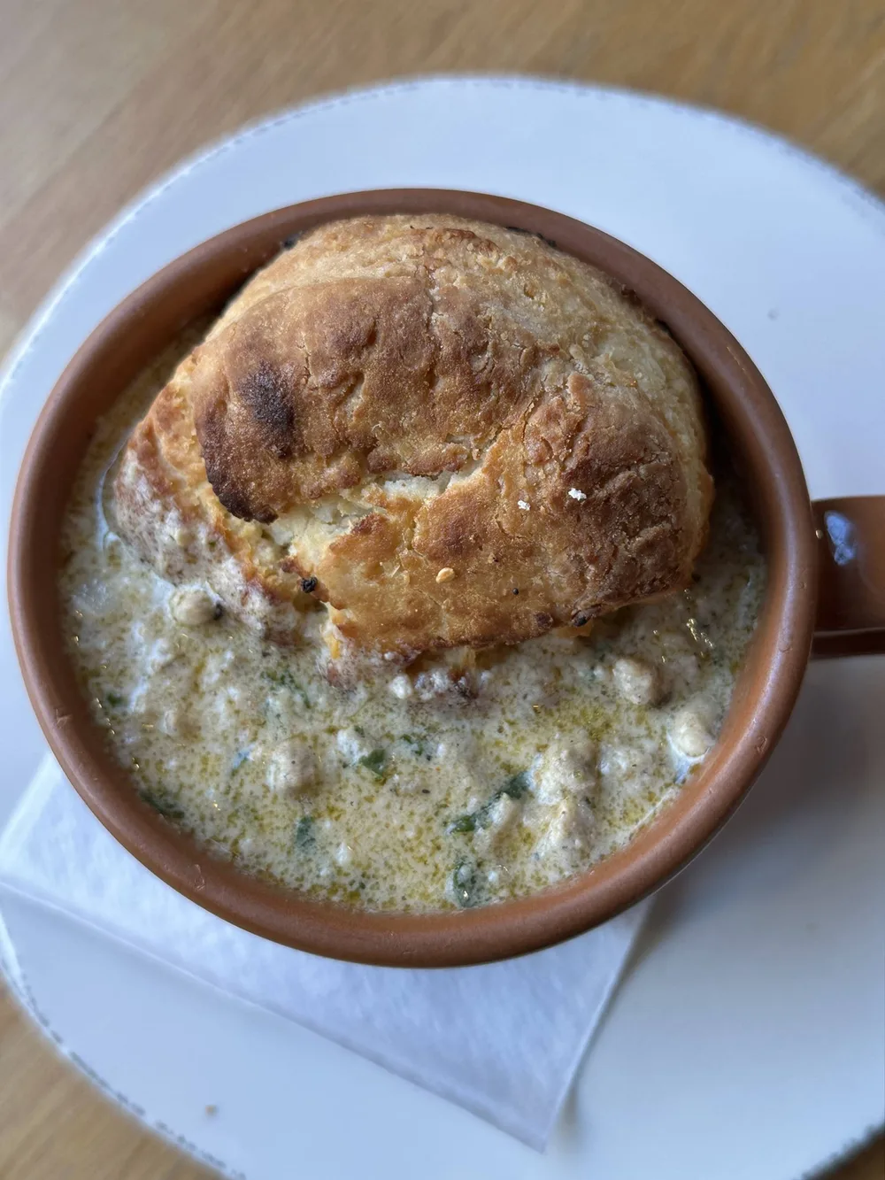 Biscuits and gravy served in a terracotta mug