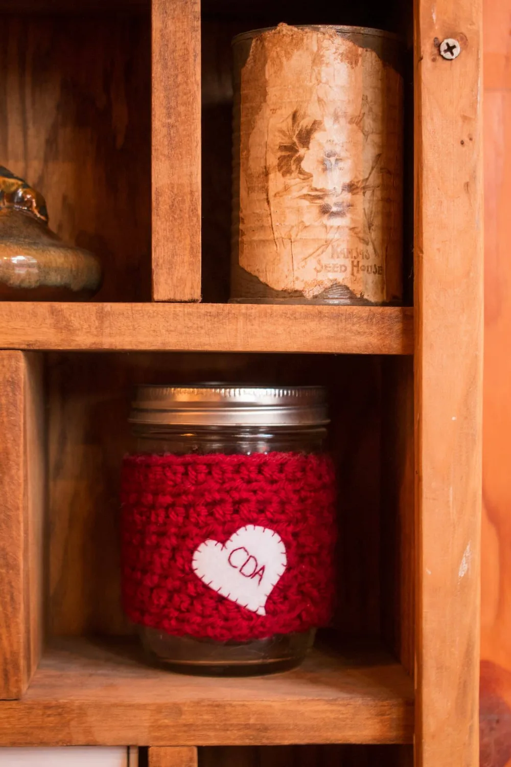 Mason jar in a red crocheted cozy with a stitched CDA heart
