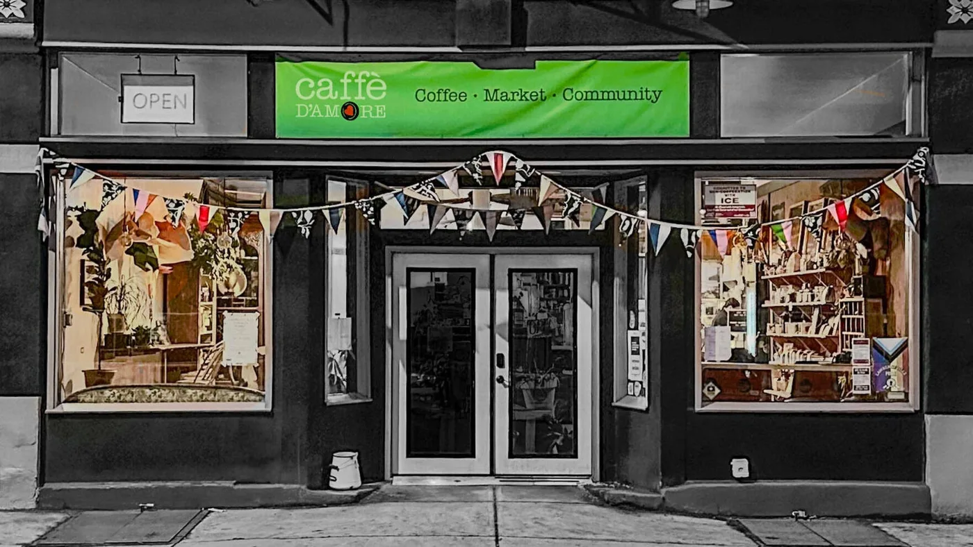 Caffè D'Amore storefront on Butler Street with its green Coffee · Market · Community banner and bunting